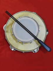 Close-up of two Brazilian percussion musical instruments: “tamborim” with drumstick  and 