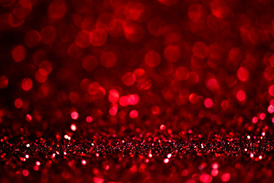 Abstract blur red glitter background card for Valentine's day, christmas and wedding celebration. Love bokeh sparkle confetti textured layout.