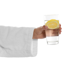 Young woman holding glass of lemon water on white background, closeup