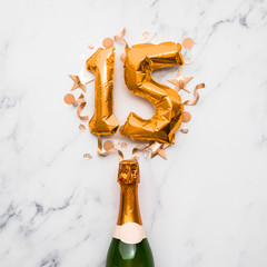 Champagne bottle with gold number 15 balloon. Minimal party anniversary concept