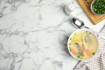 Delicious fish soup served on marble table, flat lay. Space for text