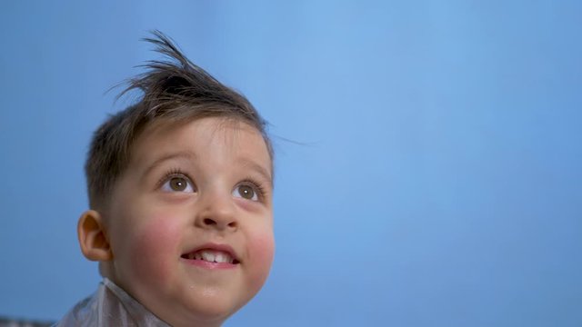 cheerful baby boy in silver holiday shirt in Studio