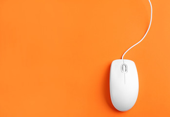 Modern wired optical mouse on orange background, top view. Space for text