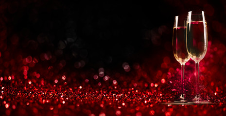Two champagne glasses on sparkling red bokeh background. Valentine's day dinner invitation. Christmas and new year holiday party. - obrazy, fototapety, plakaty