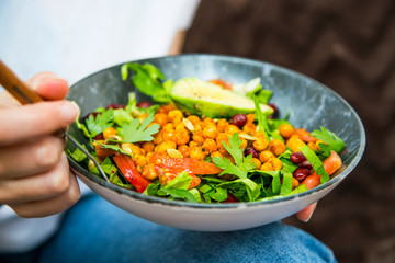 Clean eating, vegan healthy salad bowl closeup , woman holding salad bowl, plant based healthy diet with greens, salad, chickpeas and vegetables