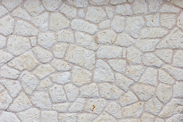 the texture of the wall is made up of pieces of different shapes of natural white stone. White...