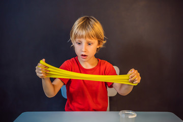 Boy playing hand made toy called slime. Child play with slime. Kid squeeze and stretching slime