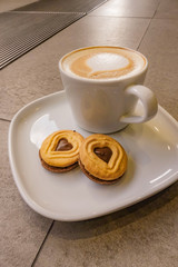 A Cup of hot latte art coffee with cookies
