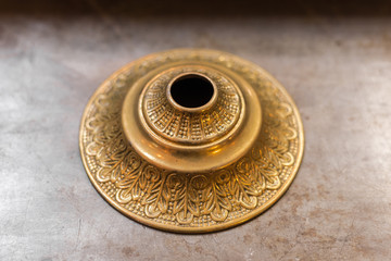 Closeup of decorative brass fixture sitting on marble table