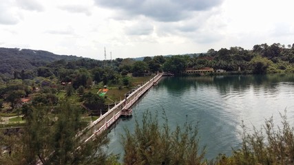 A view of dam filled with greenish appearing water with greenery around. Place : Neyyar Dam, Kerala, India