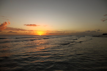 Fototapeta na wymiar Beautiful crimson red sunset from the beach over the Caribbean Sea in Barbados, Atlantic Ocean
