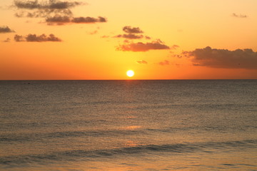 Fototapeta premium Beautiful crimson red sunset from the beach over the Caribbean Sea in Barbados, Atlantic Ocean