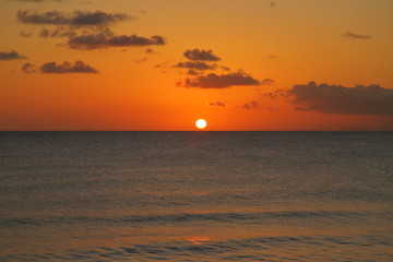 Beautiful crimson red sunset from the beach over the Caribbean Sea in Barbados, Atlantic Ocean