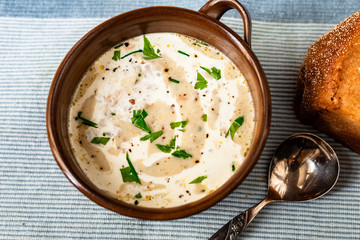 Creamy white vegetable soup, spoon and bread.