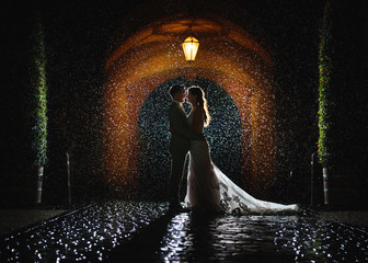 wedding - beautiful bride and groom under the rain - Powered by Adobe