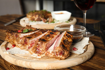 Delicious grilled ribs served on wooden table indoors