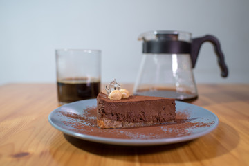 Hario v60 and chocolate cake on a large bright wooden table