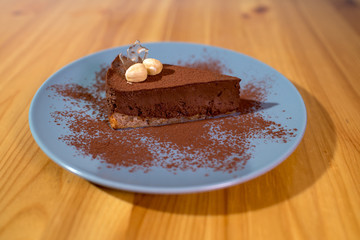 Delicious black chocolate dessert on a large bright wooden table