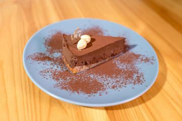 Delicious black chocolate dessert on a large bright wooden table