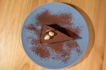 Delicious black chocolate dessert on a large bright wooden table