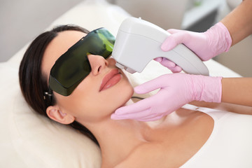 Young woman undergoing laser epilation procedure in beauty salon