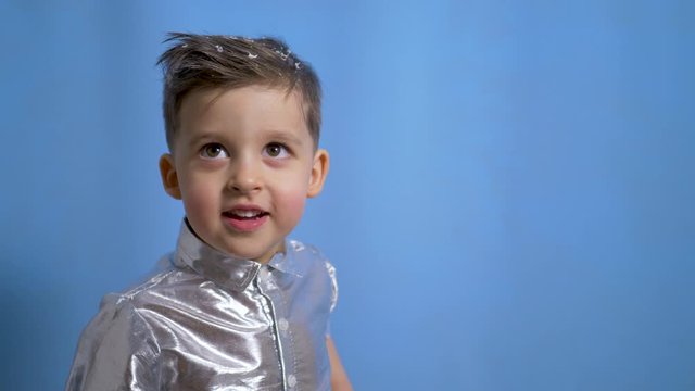 cheerful baby boy in silver holiday shirt in Studio