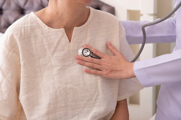 doctor listening to elderly patient's heart