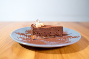 Delicious black chocolate dessert on a large bright wooden table