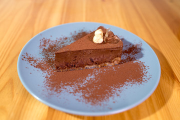 Delicious black chocolate dessert on a large bright wooden table