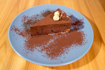 Delicious black chocolate dessert on a large bright wooden table