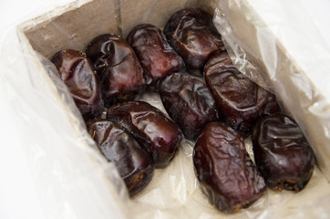 tasty dates in a box on a white background. View from above.