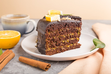 Homemade chocolate cake with orange and cinnamon with cup of coffee on a gray concrete background. side view, selective focus.