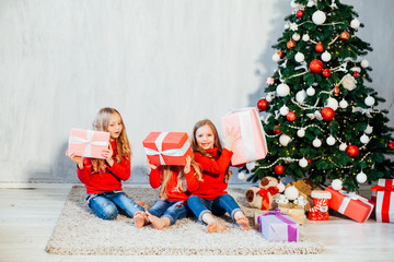 Obraz na płótnie Canvas three girls blonde sisters girlfriends gift new year tree holiday Christmas