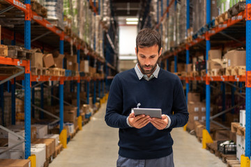 Manager holding digital tablet in warehouse