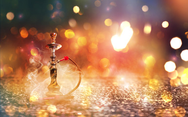 Hookah with smoke on a background of blurry lights. Abstract background, neon glow