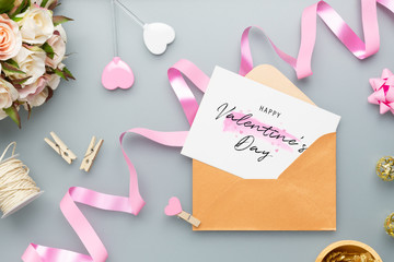 Mockup postcard and envelope on grey background with Happy valentines day, handy craft, gift box bow and pen. Mock up for elegant design. Flat lay top view valentine's day background.