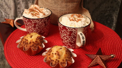 Christmas dish. Hot chocolate, cappuccino, coffee with cinnamon & spices in white & red mug. Chocolate baked muffin. Homemade baked sweet pastry. Breakfast or meal dessert. Delicious food & beverage. 