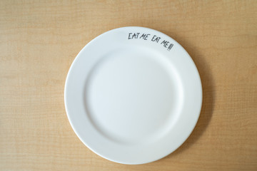 empty white plate on wooden table