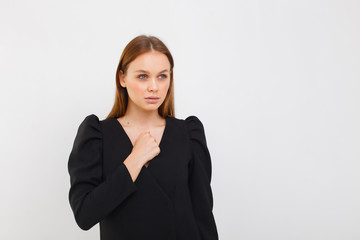 elegance woman in black dress isolated on white background. girl having serious confident look, showing clenched fist. Feminism, equality and women's liberation