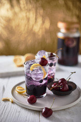 Fresh blueberry cocktail with lemon peel and cherry..