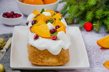 Christmas cake with marshmallow icing, cranberries, persimmons and caramelized tangerines on top.  Delicious festive dessert for Christmas and New Year.
