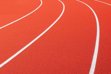 Curved white lines on a red running track