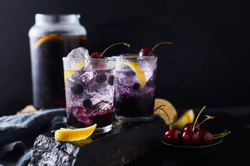 Fresh blueberry cocktail with lemon peel and cherry..