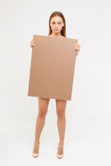 naked woman with billboard over white. nude woman holding copy space