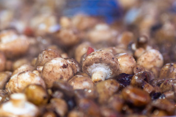 Close-up view of freshly roasted mushrooms offered on the market.