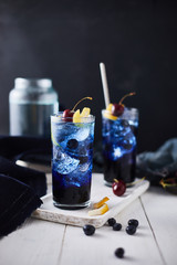 Fresh blueberry cocktail with lemon peel and cherry..