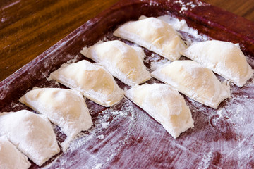 Traditional pelmeni or dumpling at cutting board.