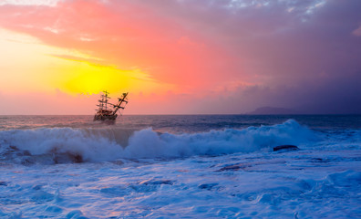 Pirate ship at the sea and a sunset
