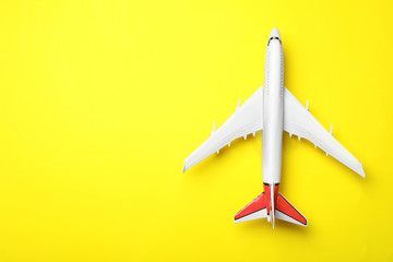 Top view of toy plane on yellow background, space for text. Logistics and wholesale concept