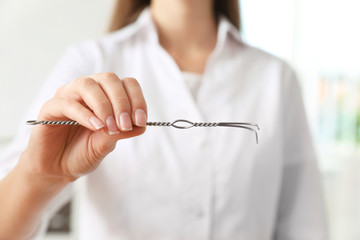 Speech therapist with logopedic probe in clinic, closeup